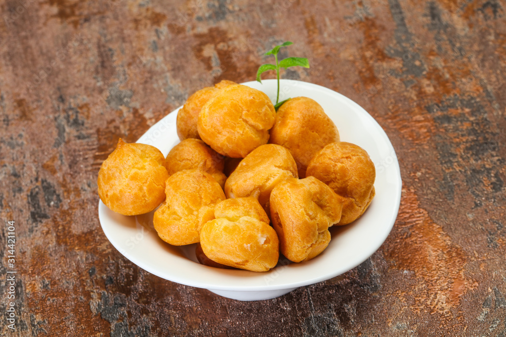 Sweet tasty profiteroles heap in the bowl Sweet tasty profiteroles heap in the bowl