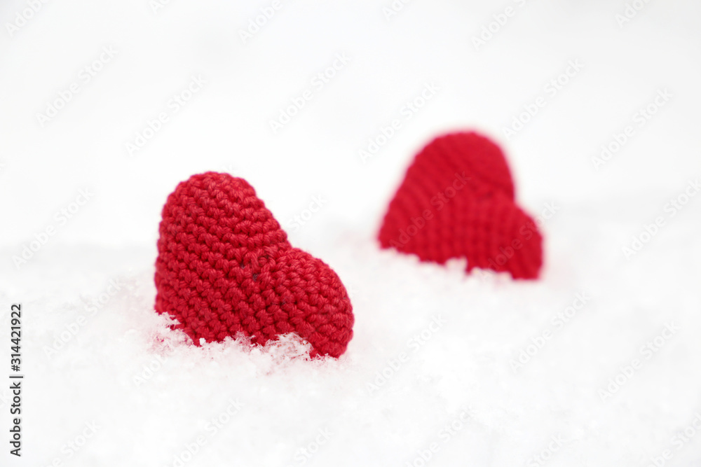 Valentines hearts, greeting card, two red knitted symbols of love in the snow. Background for romantic event, celebration or winter weather Valentines hearts, greeting card, two red knitted symbols of love in the snow. Background for romantic event, celebration or winter weather
