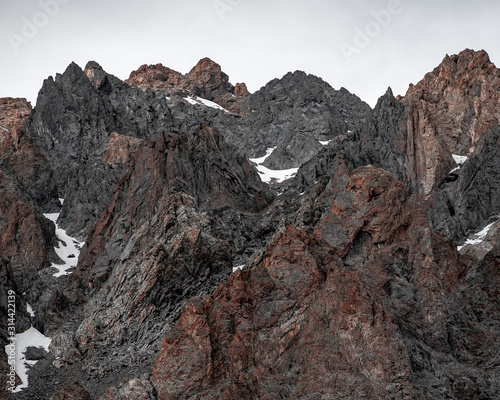 close views of the rocky heights of the mountain range under the snow