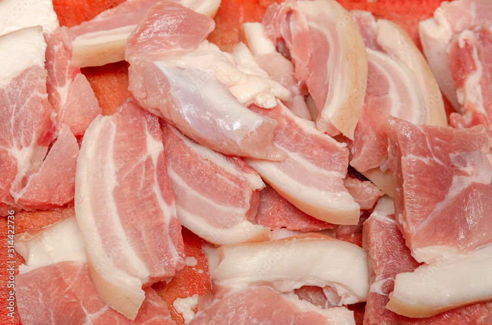 Medium-sized chunks of fresh raw pork red meat on a kitchen plank close-up. Preparation of barbecue, roast, meat dishes, food, pork. Background texture. Medium-sized chunks of fresh raw pork red meat on a kitchen plank close-up. Preparation of barbecue, roast, meat dishes, food, pork. Background texture.