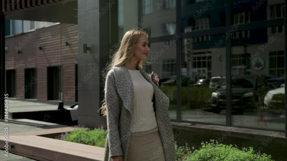 City, summer, young girl in a coat walking down the street City, summer, young girl in a coat walking down the street