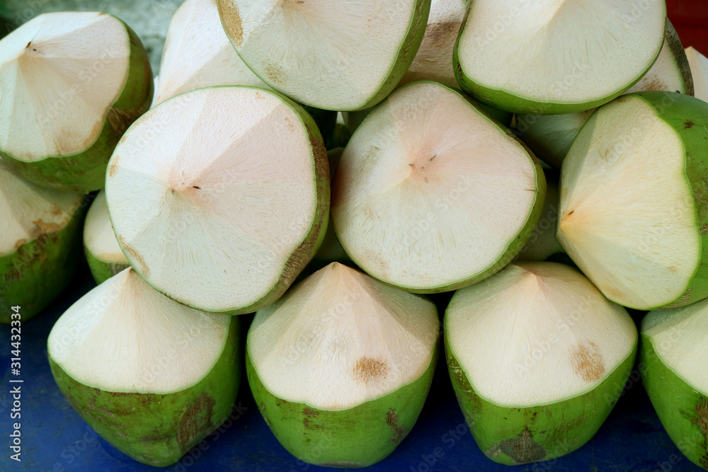 Pile of fresh young coconuts cut in the shape to be opened for drinking Pile of fresh young coconuts cut in the shape to be opened for drinking