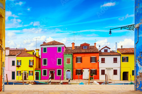 Fototapeta Naklejka Na Ścianę i Meble -  Colorful houses in Burano island with cloudy blue sky near Venice, Italy. Popular and famous tourist place