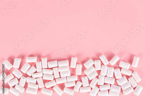 white bubble gum pills on pink background photo