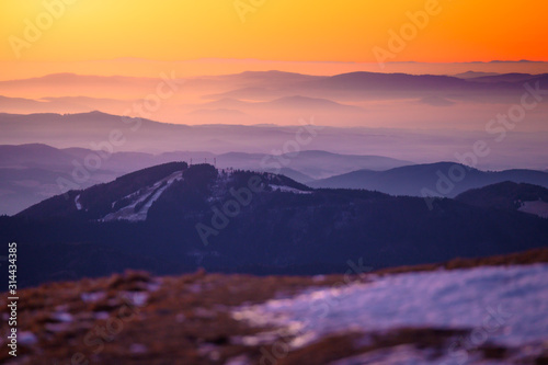 Beautiful soft orange morning light in mountains,late winter scenery with first snow © kovop58