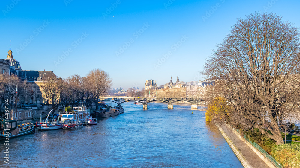 Paris, the Pont des Arts on the Seine, beautiful panorama with houseboats on the quay