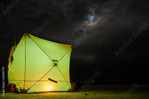 Winter fishing tent at night.