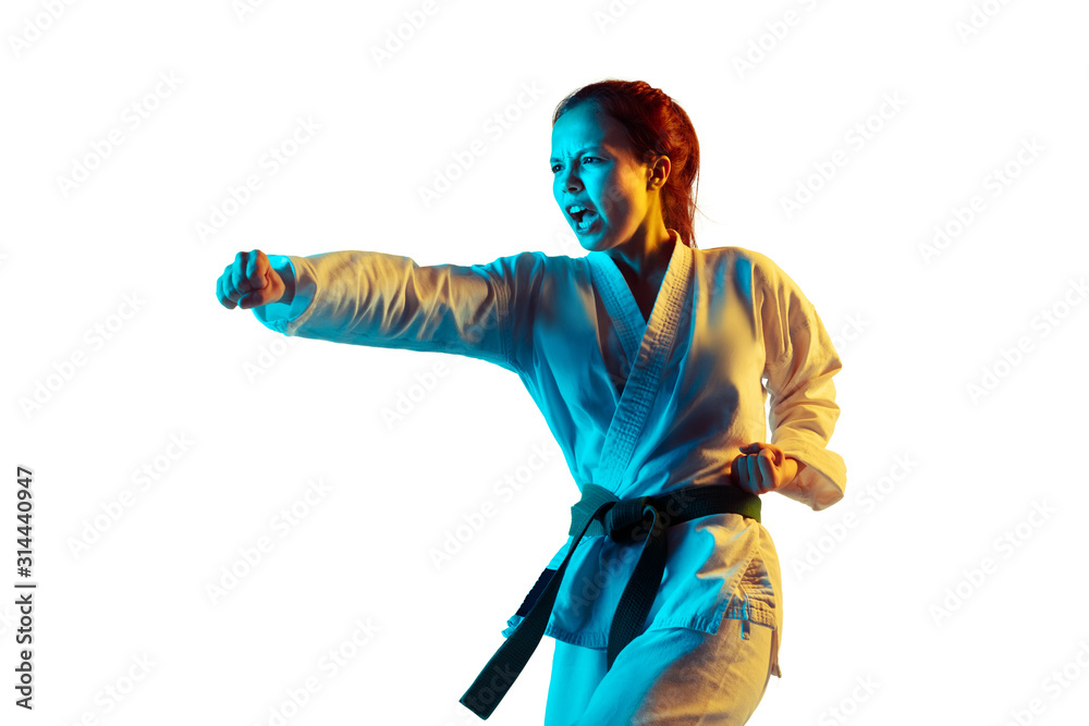 Strong. Confident junior in kimono practicing hand-to-hand combat, martial arts. Young mongol fighter with green belt training on white studio background in neon. Concept of emotions, sport, action. Strong. Confident junior in kimono practicing hand-to-hand combat, martial arts. Young mongol fighter with green belt training on white studio background in neon. Concept of emotions, sport, action.