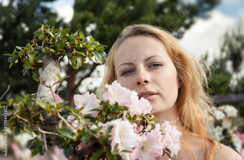 young woman among the flowers of azalea