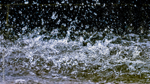 Water splash with small drops in the fountain. Abstract natural, selective focus background