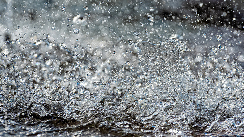Water splash with small drops in the fountain. Abstract natural, selective focus background © ako-photography