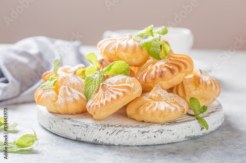 Profiteroles or gougeres (choux à la crème) - French choux pastry balls filled with custard or cottage cheese sprinkled with powdered sugar