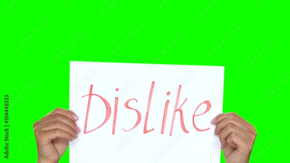 Hands showing paper with inscription dislike. Green screen. Close. Slow. Hands showing paper with inscription dislike. Green screen. Close. Slow.