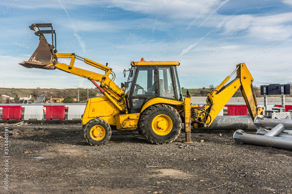 Backhoe in the construction of a roundabout with different construction materials Backhoe in the construction of a roundabout with different construction materials