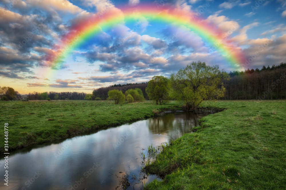rainbow over the river. picturesque spring meadow. before the storm rainbow over the river. picturesque spring meadow. before the storm