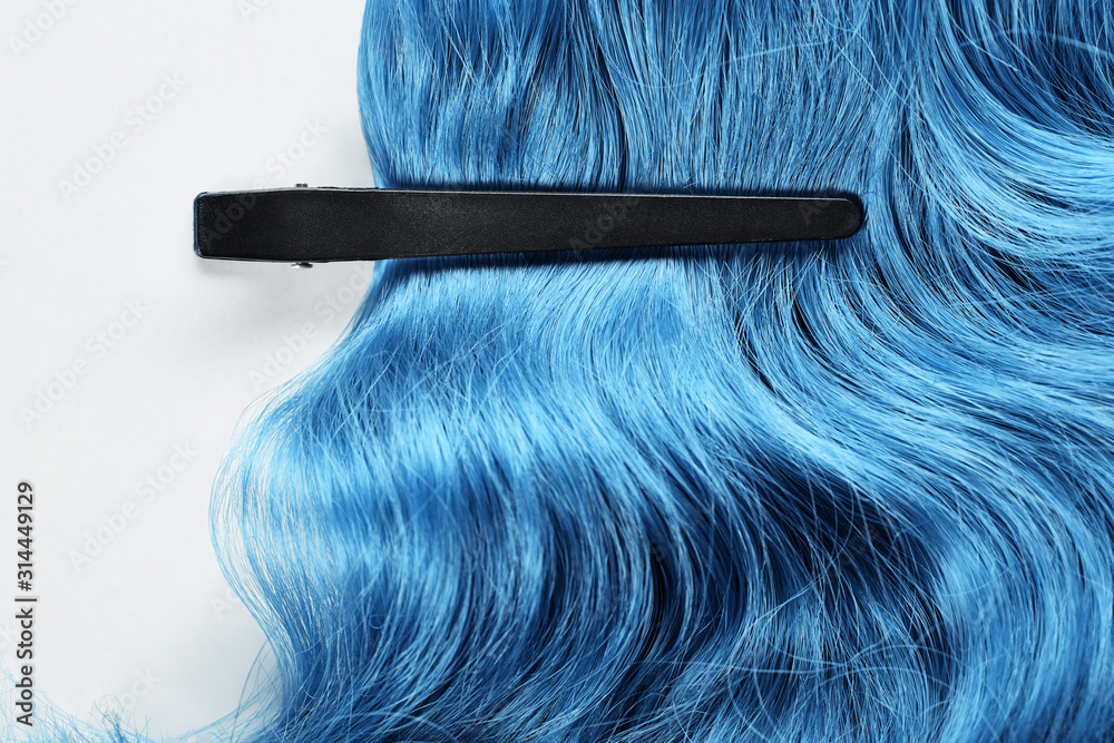 Naklejka premium Top view of clamp on blue hair on white background