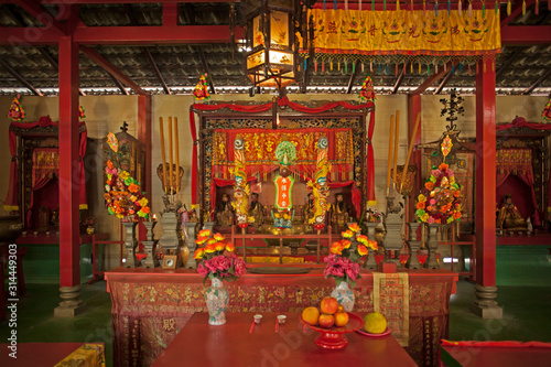 Temple bouddhiste laqué rouge et or avec offrandes à Hong-Kong. © fred.do.photo