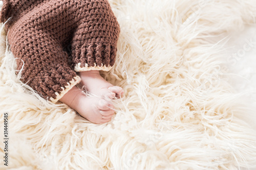 legs of a newborn baby on a white wooly background