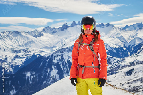 Obraz na płótnie Confident woman skier posing for a portrait in the French Alps, Les Sybelles ski domain, France, on a sunny day with perfect skiing weather. Copy space on the left. w salonie