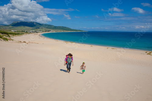landscape of wild natural beautiful Beach Bolonia in Tarifa, Cadiz, Andalusia, Spain, with woman and little girl walking. Copy or text space