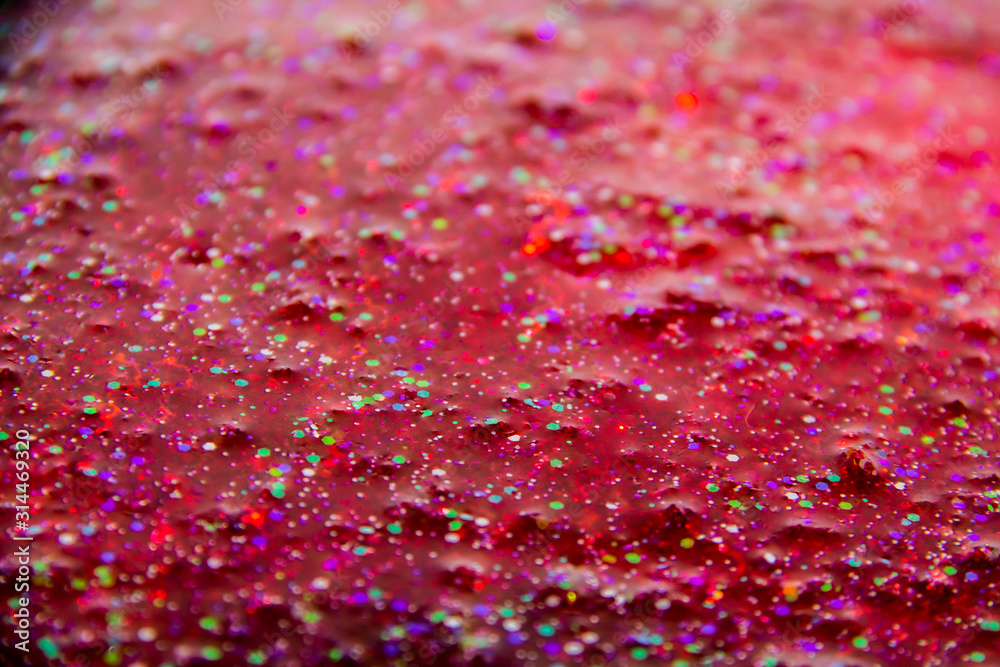 A glitter in the red liquid. Very nice background with colorful glitter. A glitter in the red liquid. Very nice background with colorful glitter.