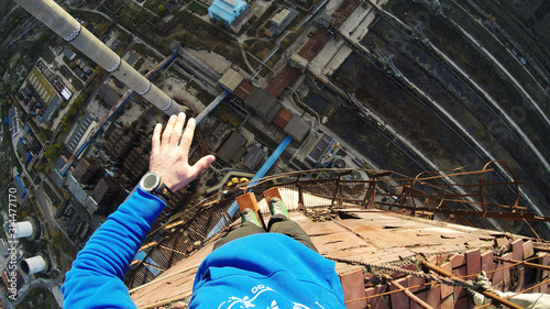 Suicidal stunt walking on a thin rail hundred meters above the ground, point of view shot, dangerous acts