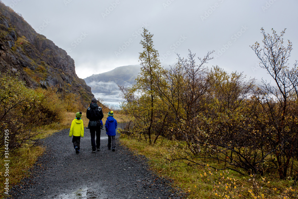 Father with children, walking on a path in beautiful nature of Skaftafell Glacier national park on a gorgeous autumn day in Iceland