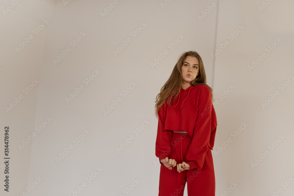 Cute teen girl actively dancing in a red suit.