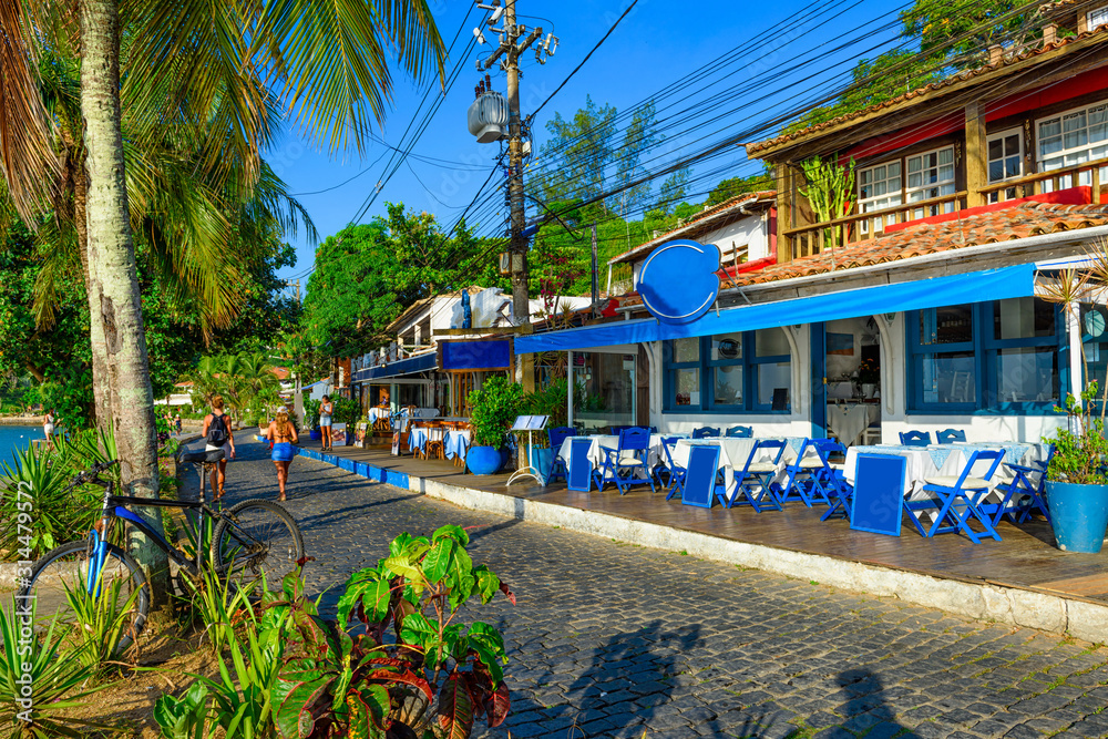 Seafront of Brigitte Bardot with palms and tables of restaurant in Buzios, Rio de Janeiro. Brazil. Cityscape of Buzios.
