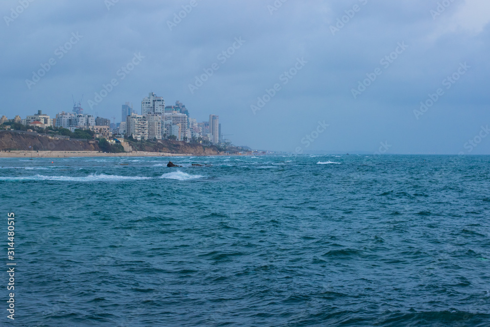 Middle East Israeli Tel Aviv suburban Mediterranean district waterfront port city soft focus buildings in fog of stormy weather time and sea wavy waters environment, copy space