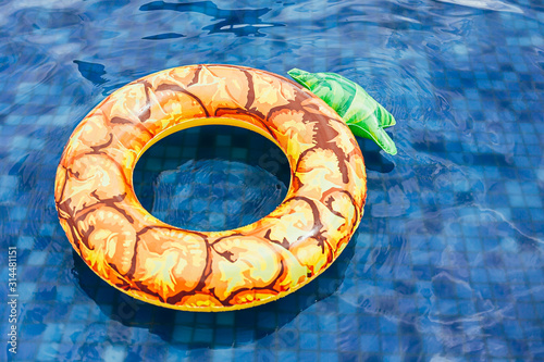 Pineapple pool float, ring floating in a refreshing blue swimming pool
