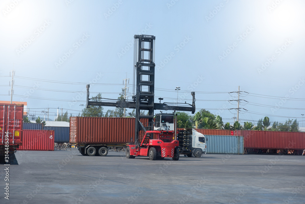 Container handlers are loading containers into trucks.