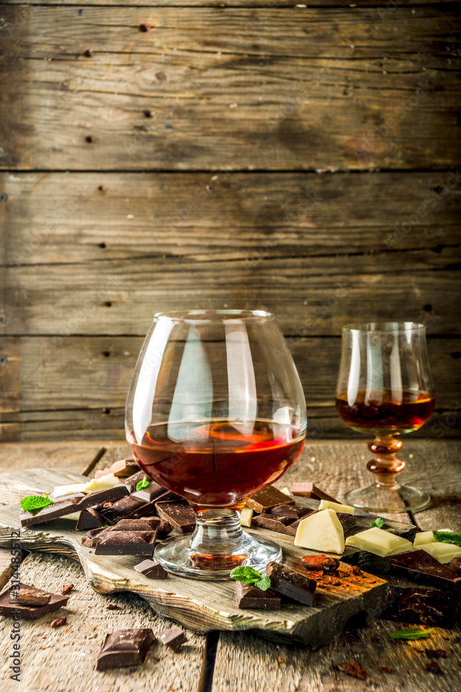 Strong alcohol drink. Glass of brandy, whiskey or cognac on the wooden table Strong alcohol drink. Glass of brandy, whiskey or cognac on the wooden table