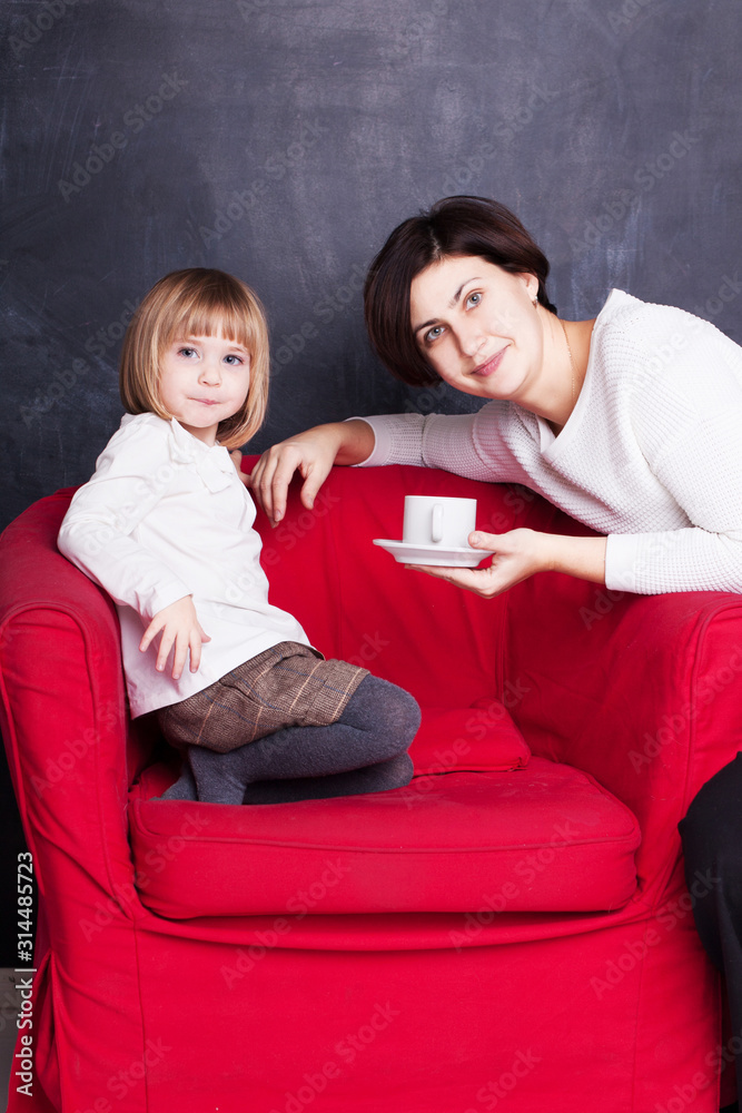 Obraz premium mom gives her baby a cup of tea