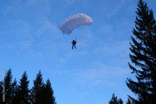 Accuracy skydiving. A skydiver is landing in the forest.