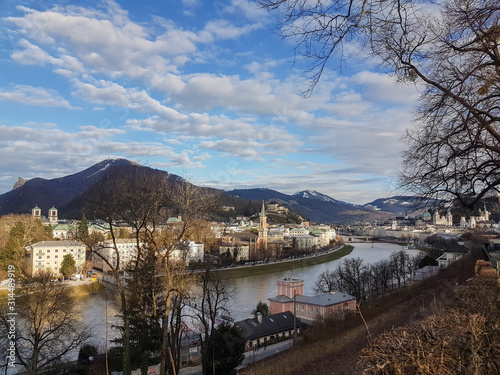 Panorama of Salzburg, Austria. River canal separates the town of Salzburg. Little town in Austria. Mountains in the background. © Olga Save