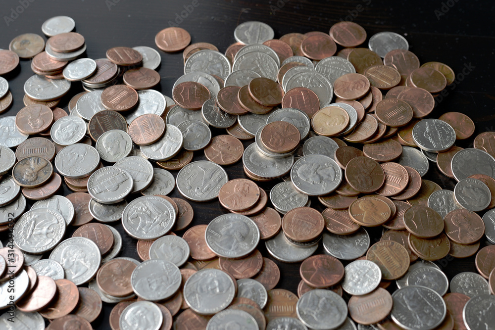 A pile of American cents on an old black wooden surface close-up. Money background A pile of American cents on an old black wooden surface close-up. Money background