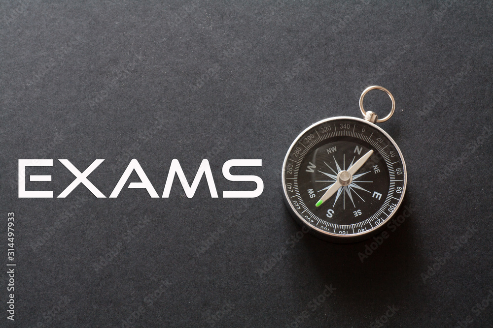 Exams word written on black background with compass Exams word written on black background with compass