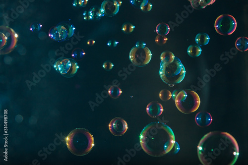 Soap bubbles colorful float on dark background