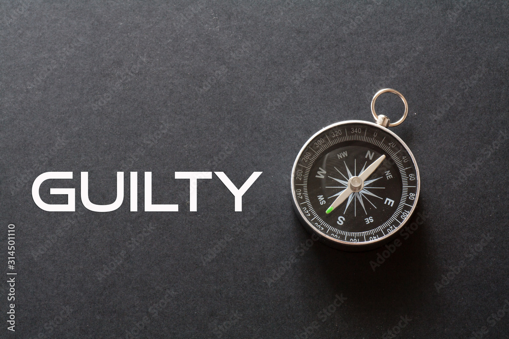 Guilty word written on black background with compass Guilty word written on black background with compass