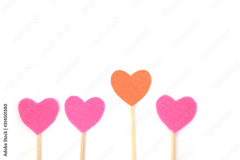Felt orange and pink hearts on a stick on a white isolated background. Stock photo for the day of St. Valentine with empty space for your text. For web, print, postcards and wallpaper.