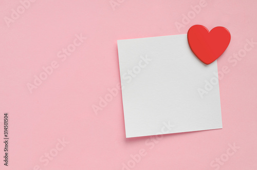 Blank paper note and red heart on pink paper background. Valentine's Day. © Soho A studio