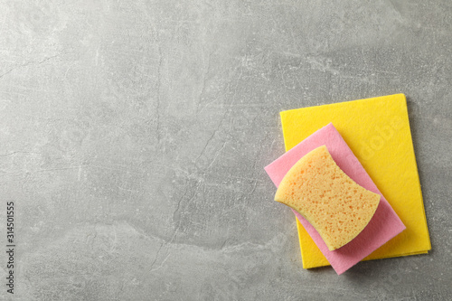 Sponges for washing dishes on grey background, top view
