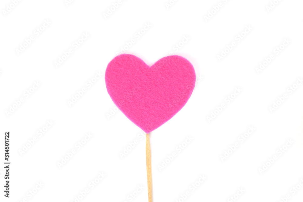 Оne pink felt heart on a stick on a white isolated background. Stock photo for the day of St. Valentine with empty space for your text. For web, print, postcards and wallpaper.