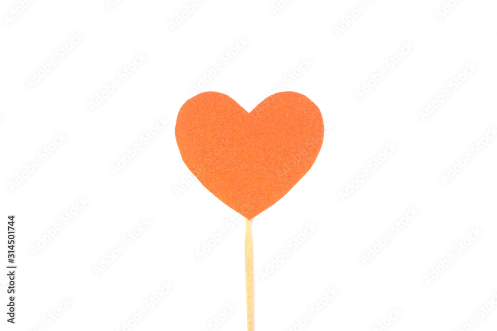 Оne felt orange heart on a stick on a white isolated background. Stock photo for the day of St. Valentine with empty space for your text. For web, print, postcards and wallpaper.