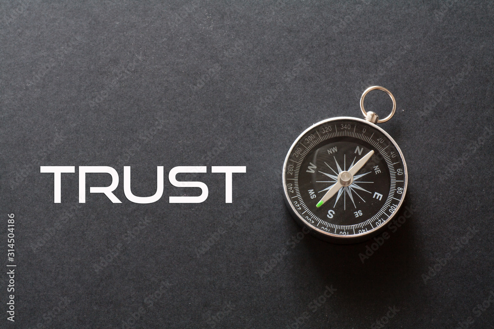 Trust word written on black background with compass Trust word written on black background with compass