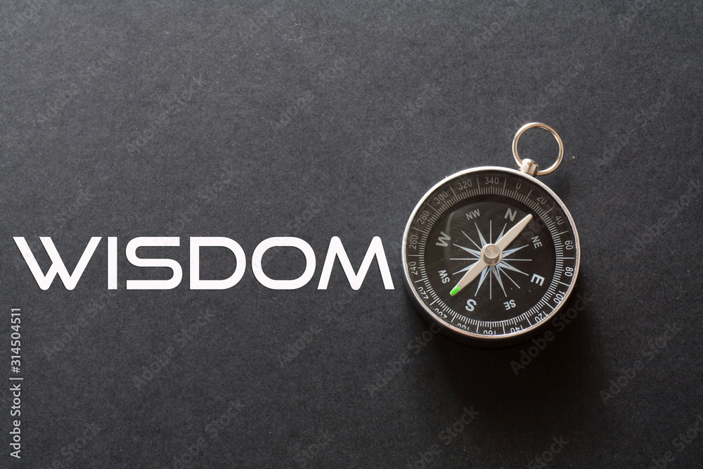 Wisdom word written on black background with compass Wisdom word written on black background with compass