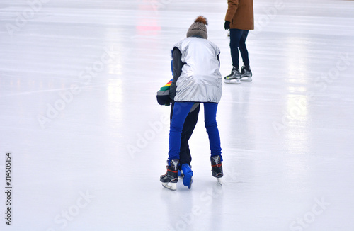 A coach teaches a child to skate