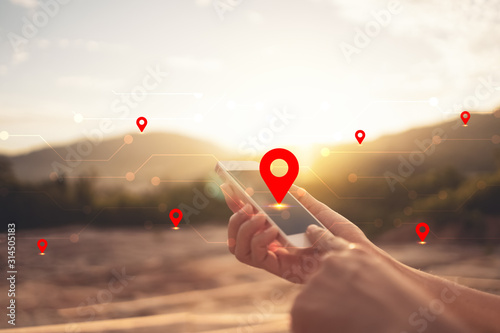Canvas Print Woman hand using smart phone on top of mountain with navigator location point abstract background