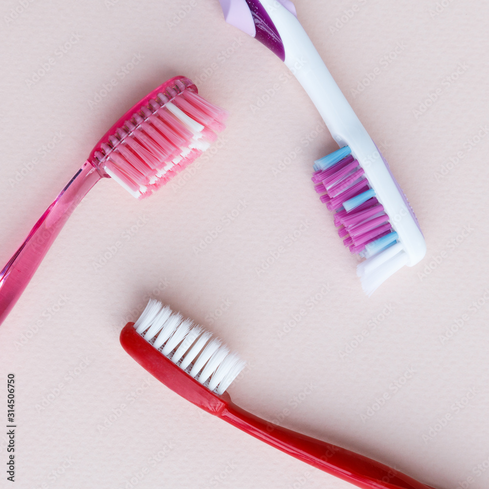 Top view of colored toothbrush with soft, medium, stiff bristles for daily use on light pink background. Top view of colored toothbrush with soft, medium, stiff bristles for daily use on light pink background.